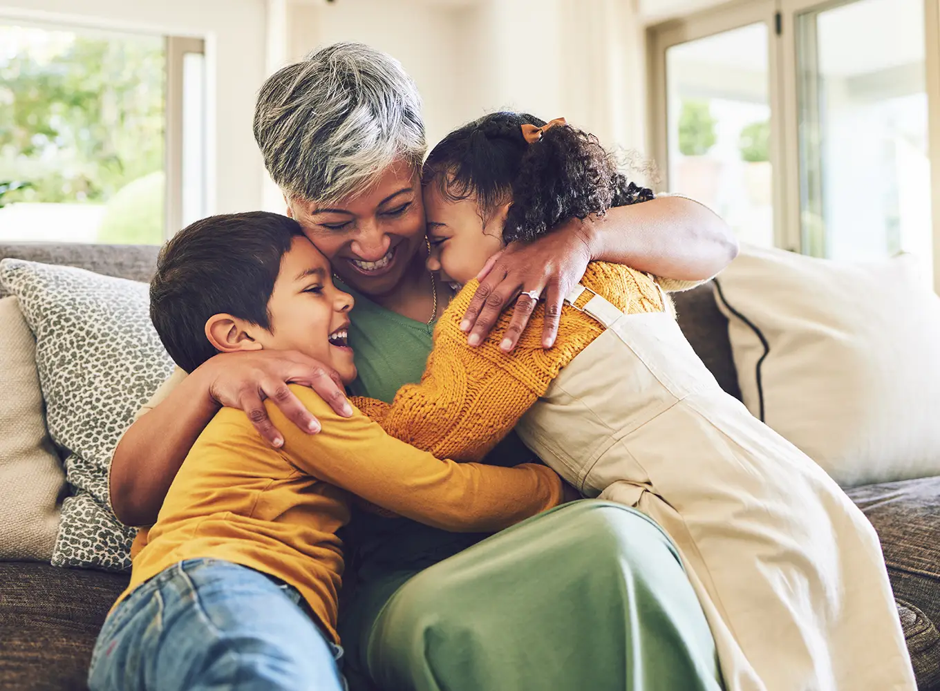 grandmother hugging her 2 grandchildren